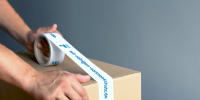 Paket wird mit Paketband zugeklebt